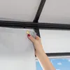 A hand is shown attaching a gray curtain to a black track system, likely part of a gazebo or pavilion. Produktbild-Vorschau