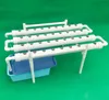 A hydroponic growing system with white pipes and a blue reservoir on a green background. Podgląd zdjęcia produktu