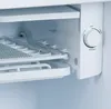 Close-up interior view of a refrigerator's cooling control dial and shelving. Voir les images du produit