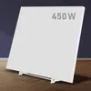A white infrared heater is shown standing on a wooden floor in front of a dark blue wall. Produktbild-Vorschau
