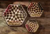 Three hexagonal chessboards of different sizes are arranged on a wooden surface. Anteprima dell’immagine prodotto