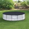 An above-ground swimming pool with a cover, set up on a grassy lawn in a backyard with trees and a house in the background. Produktbild-Vorschau