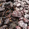 Rot-weiß gemaserte Kieselsteine gemischt mit Pinienrinde als Beetabdeckung Produktbild-Vorschau