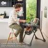 A father feeding his baby in a high chair in a modern kitchen. Produktbild-Vorschau