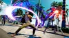 Two people are engaged in a stylized fight scene on a sunny street lined with palm trees. One person is performing a sweeping energy attack, while the other is being hit by a burst of energy. Another person is visible in the background. Produktbild-Vorschau
