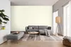 A living room scene with a sofa, ottoman, coffee table, rug, and floor lamp. Produktbild-Vorschau