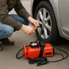 A person is using a portable air compressor to inflate a car tire. Náhled obrázku produktu