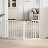 A white wooden pet gate is set up in a doorway, separating two rooms. The room on the left has a tall cabinet, and the room on the right has a sofa and a floor lamp. Náhľad obrázku produktu