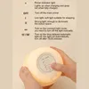 Hands holding a glowing mushroom-shaped night light, with instructions on the left. Podgląd zdjęcia produktu