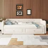 A white daybed with two drawers is shown in a room with wood-paneled walls and a patterned rug. Náhled obrázku produktu