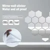 A wall decorated with hexagonal mirror stickers, with text describing the product's features. Produktbild-Vorschau