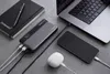 A power bank, laptop, smartphone, and earbuds are arranged on a gray surface, suggesting a tech-focused lifestyle. Náhľad obrázku produktu