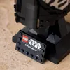 A close-up of a LEGO Star Wars Kylo Ren helmet display stand with a nameplate. Voir les images du produit