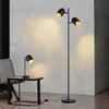 A modern living room setting with a floor lamp and a table lamp. Produktbild-Vorschau