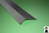 A metal corner profile is placed diagonally on a green surface. Produktbild-Vorschau