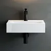 A white ceramic sink with a black faucet mounted on a dark gray wall. Produktbild-Vorschau