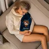 A woman is lying on a couch, holding a Harry Potter-themed hot water bottle. Anteprima dell’immagine prodotto