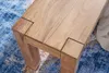 A close-up view of the corner of a wooden bench on a blue patterned rug. Anteprima dell’immagine prodotto