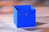 A blue fabric storage box sits on a wooden floor. Podgląd zdjęcia produktu