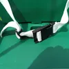 A close-up of a white strap and black buckle attached to a green surface. Náhled obrázku produktu