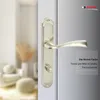 A close-up of a nickel-colored door handle on a white door, with a blurred background of a room interior. Produktbild-Vorschau