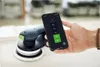 A hand holds a smartphone displaying an app interface next to a Festool cordless orbital sander. Voir les images du produit