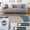 Grauer gesteppter Sofabezug auf einem Holzsofa, mit Waschmaschine und Texteinblendungen zur Produkthaltbarkeit Náhľad obrázku produktu