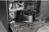 A dishwasher interior with a black appliance part in the top rack. Podgląd zdjęcia produktu
