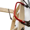 A close-up view of a red handle attached to a wooden attic ladder. Produktbild-Vorschau