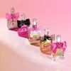 A collection of Juicy Couture Viva La Juicy Noir perfumes displayed on a pink background. Podgląd zdjęcia produktu