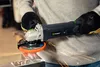 A person wearing gloves is using an angle grinder, creating sparks. Náhled obrázku produktu