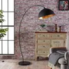 A floor lamp is positioned next to a cabinet with decorative elements and a chair with a blanket. Produktbild-Vorschau