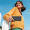A young woman is holding a black smartphone case in front of her, with a bright blue sky in the background. Náhled obrázku produktu