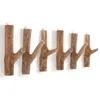 A set of wooden branch-shaped hooks mounted on a white wall. Náhled obrázku produktu