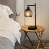 A bedside table with a vintage-style desk lamp next to a bed. Podgląd zdjęcia produktu