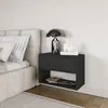 A black wall-mounted nightstand with a drawer and an open shelf, placed next to a bed. Voir les images du produit