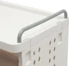 A close-up view of the top corner of a white laundry basket with a gray handle. Náhled obrázku produktu