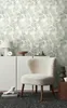 A room interior with a chair and a cabinet against a patterned wallpaper. Produktbild-Vorschau