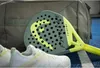 A padel racket, bag, and shoes are arranged on a blue court. Podgląd zdjęcia produktu