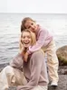 A mother and daughter are posing for a photo by the water. Produktbild-Vorschau