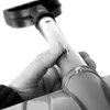 A hand is holding a part of a snow shovel, showing a button mechanism. Náhled obrázku produktu