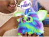 A child is interacting with a colorful Furby toy. Podgląd zdjęcia produktu