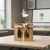 A gift box with a small plant inside, placed on a desk in an office or home office setting. Náhľad obrázku produktu
