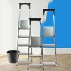 Three aluminum step ladders of different heights are arranged in front of a wall with blue paint splatters. Podgląd zdjęcia produktu