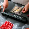 A person uses a vacuum sealer to seal food in plastic bags. Produktbild-Vorschau