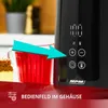 A close-up of a black and red electric kettle with a digital display and control buttons, next to a glass of red liquid and a slice of cake. Produktbild-Vorschau
