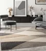 A modern living room scene featuring a geometric patterned rug, a chair, and a sofa. Produktbild-Vorschau