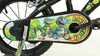 A close-up of a children's bicycle chain guard with cartoon dinosaurs. Voir les images du produit