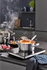A kitchen scene with multiple pots and pans cooking on an induction hob, with steam rising. Podgląd zdjęcia produktu