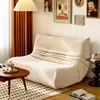 A cozy living room scene featuring a beige sofa, a coffee table with decorative items, and artwork on the wall. Produktbild-Vorschau